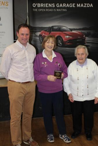 Eileen Simpson (St.Michaels) receiving Division 7 runners up Plaque from Roy Corbett, O'Briens Garage